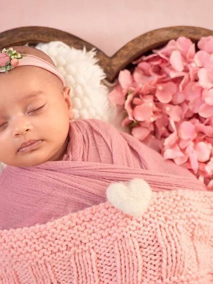 Tucked into a heart-shaped bowl with a cozy pink blanket, this little one is surrounded by love and sweetness.