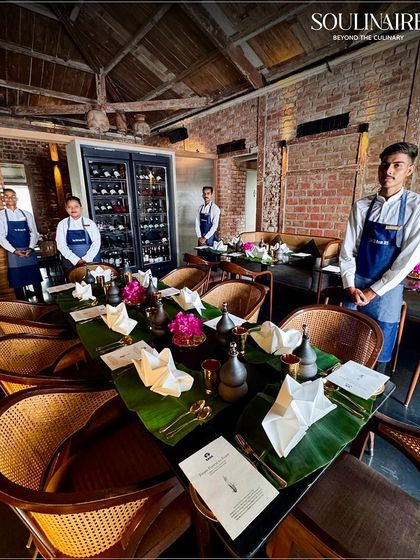 Our service team stands ready at the 'Forest to Feast' event, with tables set with banana leaves and rustic decor. We are committed to delivering authentic and meaningful dining experiences.