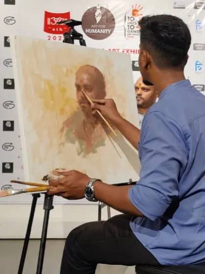 Working on a live portrait at the Kamalnayan Bajaj Art Gallery. This image captures a moment of intense focus as I use a fine brush to render the details of the subject's face.