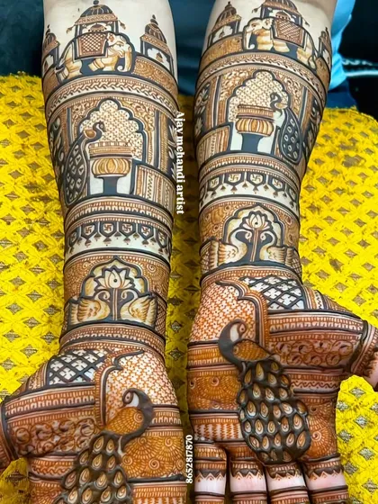 A very detailed bridal design featuring peacocks on the palms and elephants and palace scenes on the forearms. The shading creates a beautiful 3D effect.