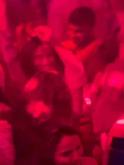 A blurry, red-tinted shot capturing the chaotic energy of the dance floor.
