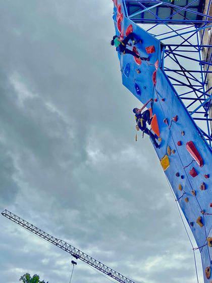 Two climbers make their way up the competition wall during the Independence Day Cup 2025 in Davangere.