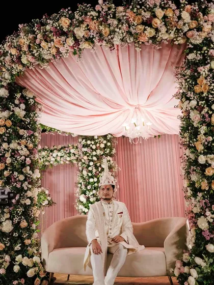 For Sakshi and Shuvam's wedding, we created this opulent mandap under the stars. The structure was completely covered in lush pink, peach, and white florals, with a soft fabric canopy and a chandelier for a touch of timeless elegance.