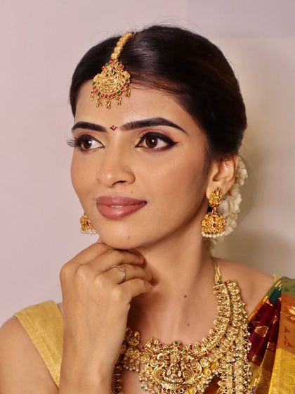 A full-face shot of the radiant South Indian bride, showcasing the complete look with hair, makeup, and jewelry, all part of our comprehensive training.