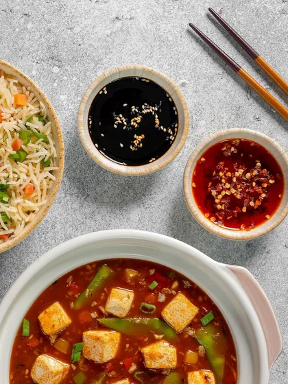 A detailed shot focusing on the condiments served with the Mapo Tofu meal.