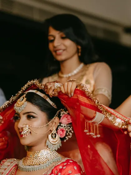 Another angle of the bride getting ready, surrounded by her friends.
