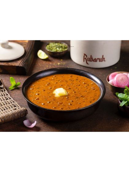 Dal-e-Rubaruh, a version of Dal Makhani, presented in a traditional setting. The dollop of butter is the focal point, conveying a sense of richness and authentic flavor.