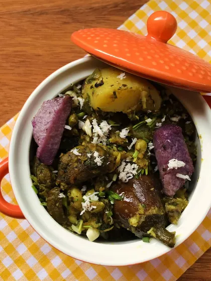 A warm pot of our authentic Surti Undhiyu, a traditional Gujarati winter vegetable casserole. It's packed with seasonal vegetables like purple yam and baby brinjal, slow-cooked in a green masala.