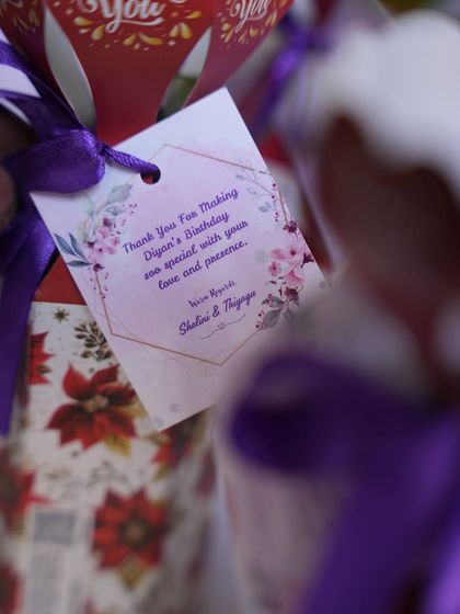 A close-up of the personalized thank you tag attached to the return gifts, adding a heartfelt touch from the hosts.