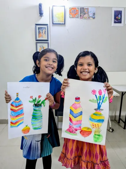 Aradhya and Usra from our junior batch with their colorful still life paintings of vases. Their bright smiles match their vibrant artwork.