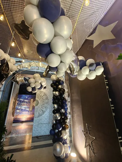 Another view of the musical-themed entrance tunnel, showing the path lined with star props and balloon garlands. This perspective highlights the depth and immersive quality of the decoration.