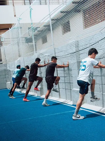 Wall drills are a fundamental tool for teaching proper acceleration mechanics. Here, athletes work on maintaining a forward lean and powerful leg drive, reinforcing the body angles required for an explosive start.