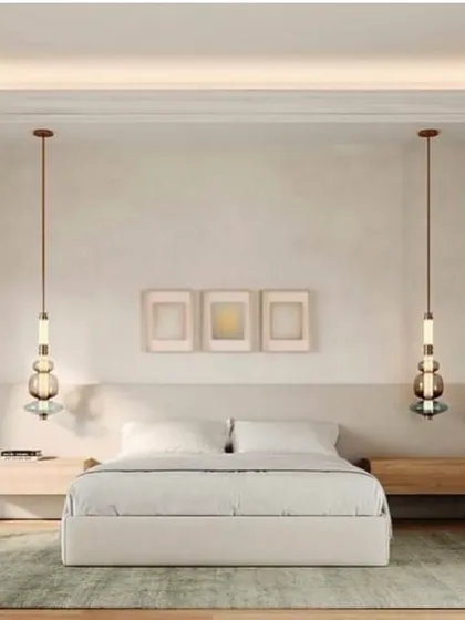 Two Luna Kaleido pendants flank a bed, offering a symmetrical and sophisticated alternative to traditional bedside lamps. Their vertical form draws the eye upwards.