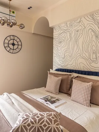 A full view of this imaginative kids' room, showing the bed with its unique topographic map wallpaper, a large wall clock, and a balcony that lets in plenty of natural light.