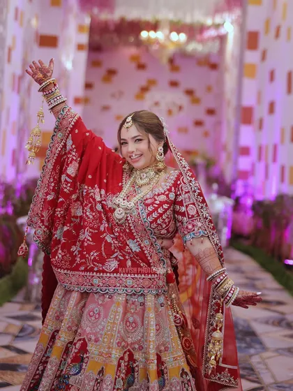 A joyful, candid shot of the bride with her arm raised in celebration, capturing the energy and excitement of her wedding day.