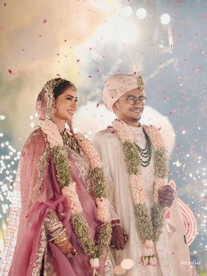 A fairytale moment under a shower of fireworks. The bride's makeup is luminous, catching the light beautifully for a truly magical wedding portrait with her groom.