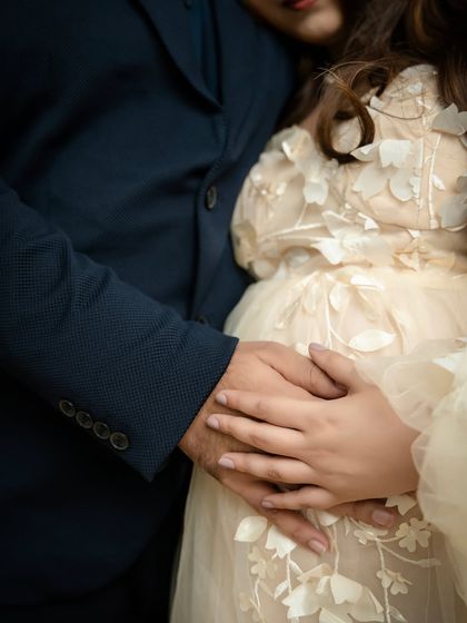 A promise of protection. This close-up on the couple's hands cradling the bump is a simple, powerful symbol of their shared commitment and love.