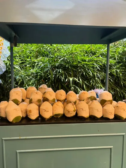 It's the small details that make a big difference. For a tropical-themed daytime event, we served refreshing coconut water in coconuts personalized with the couple's wedding hashtag.