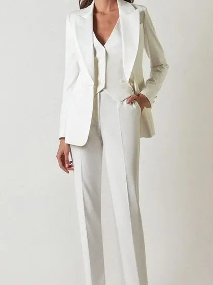 A timeless and elegant choice, this custom white three-piece power suit features a tailored blazer, waistcoat, and straight-leg trousers for a crisp, clean look.