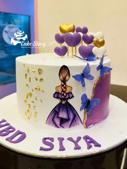 A beautiful cake for a little queen. This design features a girl in a purple dress, with purple hearts, blue butterflies, and gold leaf accents.