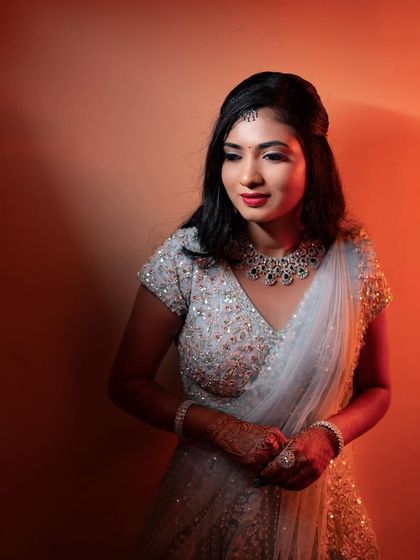 The warm, orange lighting creates a beautiful contrast with Rakshita's light blue lehenga, highlighting the versatility of the makeup.