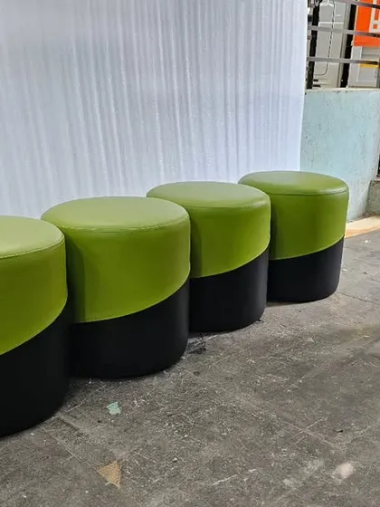 A set of custom-made poufs in a two-tone green and black leatherette, ready for delivery. These were made for a commercial client.