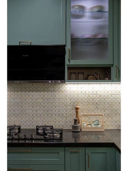 A close-up of the kitchen's floral backsplash and shaker-style cabinets. The design ensures a clutter-free and practical space that is enjoyable for daily use.