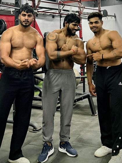 My clients call me 'Guru Ji', and I take that responsibility seriously. Here I am with two of my dedicated students, guiding them on their path to building a better physique.
