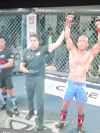 A champion's moment. One of our fighters celebrating his win inside the cage, a culmination of months of relentless training and preparation.
