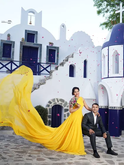 A splash of sunshine and joy. This vibrant shot, with its stunning yellow gown and Santorini-inspired architecture, shows how we can create a fun, destination-style shoot full of energy and romance.