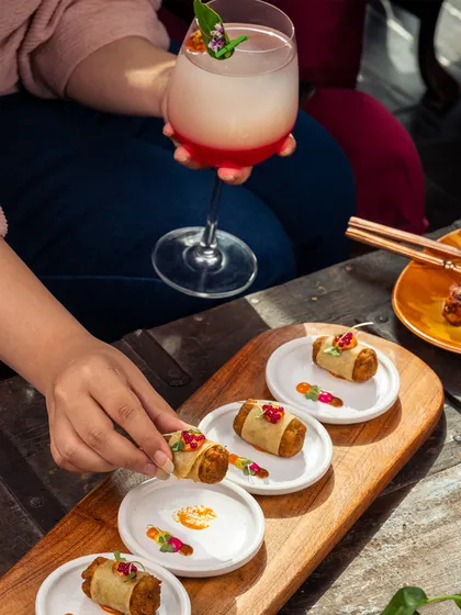 A beautiful spread of our global appetizers. From Asian-inspired rolls to Mediterranean bites, it's a perfect way to start your culinary journey with us, paired with a refreshing cocktail.