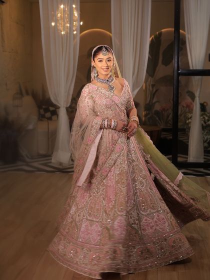A full shot of the modern pink bridal lehenga, showing its beautiful flare and the way the double dupatta is styled.