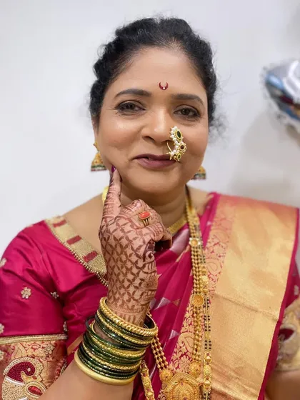 A playful pose from the mother of the groom, showing off her intricate henna and classic makeup.