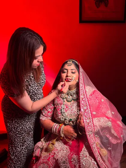 Another shot of me applying lipstick under dramatic red lighting. This shows the intense, artistic environment we sometimes work in.