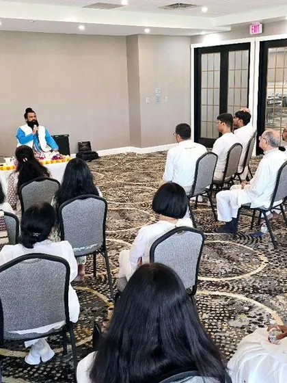 A wide shot of our satsang in the USA, showing the arrangement and the attentive audience. We ensure our venues are comfortable and conducive to spiritual learning.