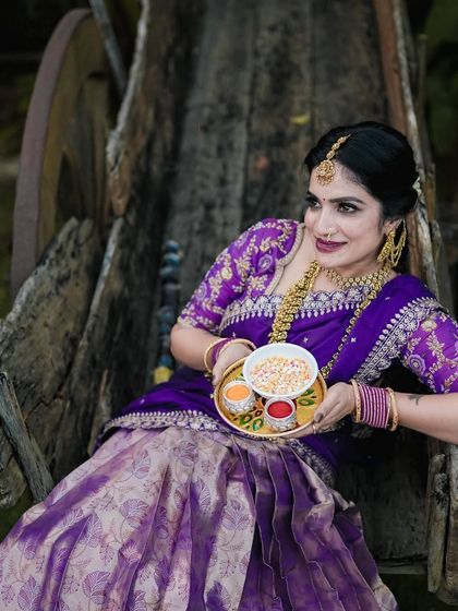A close-up from the same Sankranti session, showing the woman seated in a rustic wooden cart, holding a traditional offering plate.