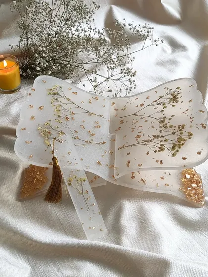 This is my resin holy book stand, or rihal, designed to be both beautiful and functional. I've embedded delicate sprigs of baby's breath and scattered gold flakes into the clear resin, creating a serene and elegant piece for your daily prayers or reading. It also comes with a matching bookmark.