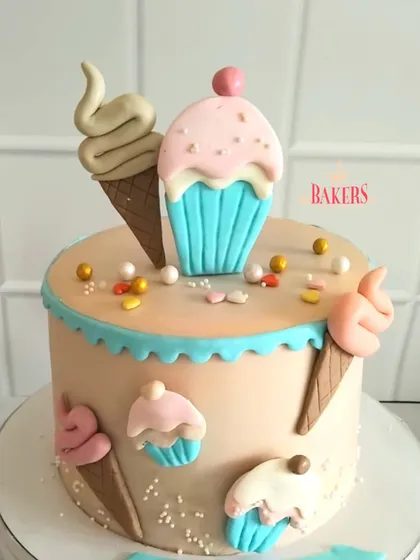 Cuteness overload with this Candyland-themed cake for Aahana's 9th birthday. The cake is decorated with fondant ice cream cones and cupcakes in sweet pastel colors.
