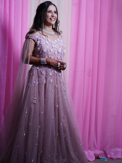 Another one of our happy clients enjoying her event in a beautiful mauve gown. The off-shoulder cape and delicate floral embroidery create a soft and romantic look.