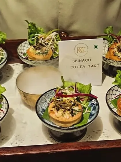 A tray of our savory Spinach and Ricotta Tarts. These flaky pastries are filled with a creamy cheese and spinach mixture, making for a perfect vegetarian appetizer at any social gathering.