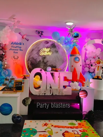 A first trip around the sun with our out-of-this-world space theme. This design includes a large moon backdrop with a neon "Happy Birthday" sign, custom astronaut and rocket ship props, and planetary details to create an immersive galactic adventure for a first birthday.