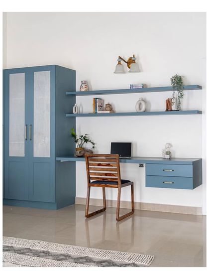 The guest bedroom, featuring a built-in study nook and wardrobe in the same calming blue hue. Faux walls were used to conceal a roomy walk-in wardrobe, providing ample storage.