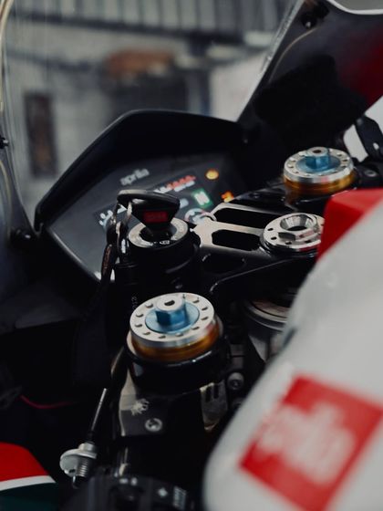 A close-up of the cockpit of an Aprilia RSV4. The adjustable top yoke and aftermarket components show the level of detail we put into our track builds.