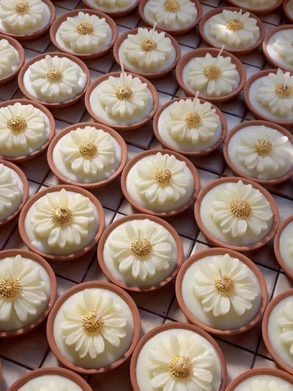 Another shot of our popular earth pot daisy candles, catching the light beautifully. These are perfect for bulk orders for Diwali, weddings, or any celebration.
