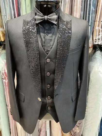 For a bold, unforgettable party look. This custom three piece suit features a striking black sequin lapel and a matching bow tie, designed to catch the light and ensure you are the center of attention.