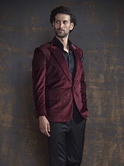 A rich maroon velvet blazer, perfect for adding a touch of luxury to an evening look. The fabric has a subtle texture that adds depth and sophistication.