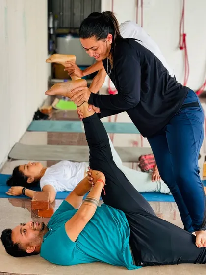 Partner work is a great way to build trust and go deeper into stretches. Here, a student assists another with a supine hamstring stretch.