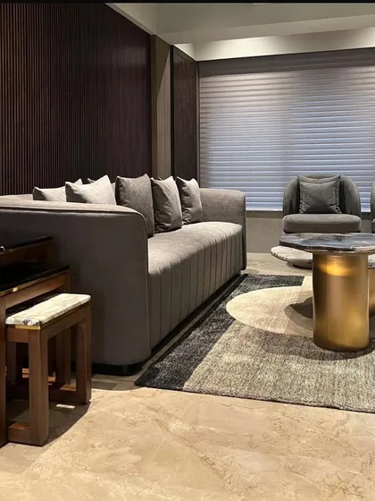 A view of the living room in the Juhu apartment, where I used a combination of soft textiles, dark wood paneling, and a graphic rug to create a space that is both comfortable and visually sophisticated.