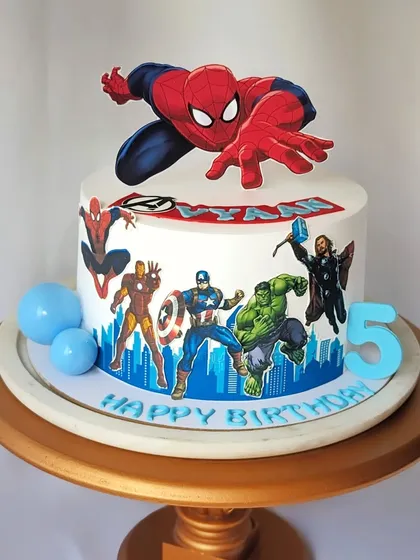 Avengers assemble! This non-fondant cake is perfect for a superhero party, featuring Spider-Man, Iron Man, Captain America, Hulk, and Thor against a city skyline.