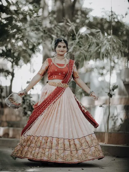 For the Makara Sankranthi festival, I designed this exquisite Zari Kota lehenga for my client. The peach skirt with a traditional border is paired with a red brocade blouse, creating a vision of grace and tradition.